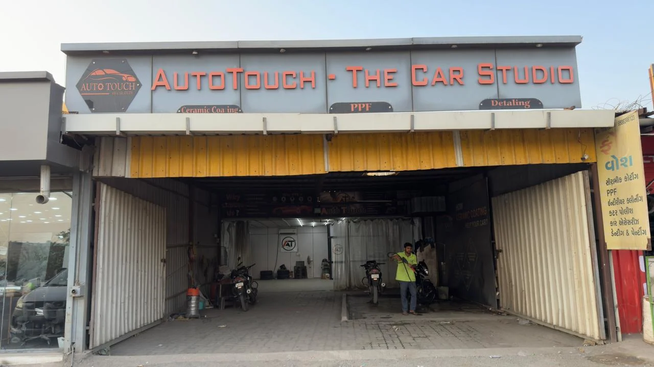 Auto technician at a professional car studio providing expert vehicle detailing, PPF installation, ceramic coating, and automotive maintenance services.